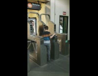 Dad helps his son swipe metro card at turnstile