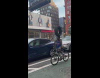 Guy bikes with tire on head 
