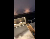 Baby boy takes bubble bath with candles 