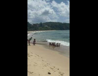 Three guys lay on beach feet upward