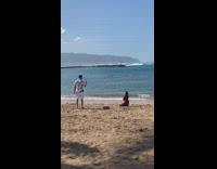Woman gets her picture taken by the beach 