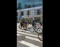 Large group of bicyclists wheelie salesforce tower 