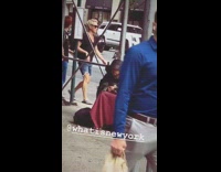 Guy black cloak sits on sidewalk with pigeons on body and head 