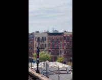 Man in underwear wave arms on rooftop