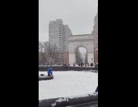 Guy sitting on water fountain raps microphone 