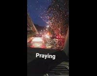 A car drives through flooded street cars stuck