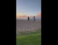 Woman in black shirt fires an imaginary arrow at the beach