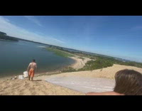 Black helmet guy slides down hill lake 