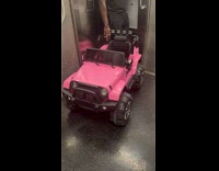 Small pink jeep wrangler inside subway train