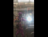 Guy in purple dinosaur onesie carries Bird electric scooter through turnstile at subway station