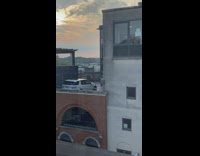 Woman brown dress holds handbag spins rooftop