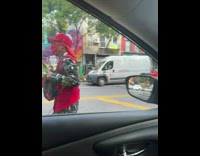 Guy red cap baby yoda puppet street