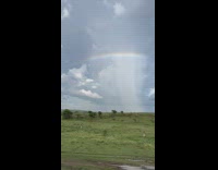Rainbow arc in the sky with rain underneath