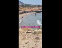 Guy orange shorts walk from sea rocky