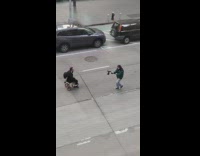 Guy rides small red tricycle down street