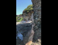 Woman pink bikini surfboard rocks tiktok video shoot