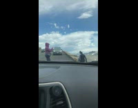 Girl sits edge of mountain street road
