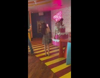 Lady in satin dress twerks on pink cake at museum 