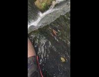 Guy sit on edge of waterfalls slippers