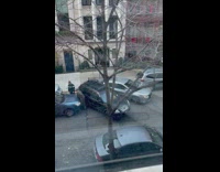 Two poorly parked cars block street 