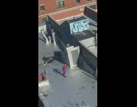 Guy in spiderman costume doing kicks on rooftop