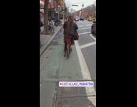 woman black jacket red bike really long brown hair