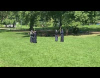 4 people in black have stick battle at park 