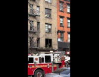 Firemen at apartment building window that got burned
