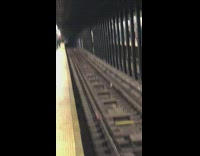 man with long curly black hair sings on subway platform