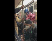 Man with blue lucha libre hat drinks beer on train