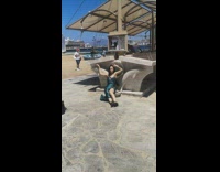 Woman in green satin dress sits near the beach