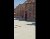 Woman red shirt sing beside temple stairs