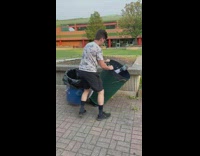 Guy helps stranger stuck inside trash can 