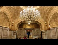 People pray in temple with golden ceiling