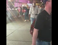 Grey shirt guy dances busy sidewalk 