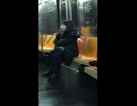 Lady on subway holds hand warmer 