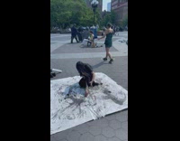 Woman paints black ink with body on paper 