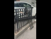 White car parked on sidewalk next to garage 