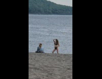 Woman black bikini hold hair pose beach