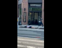 Man laying down and smoking on sidewalk