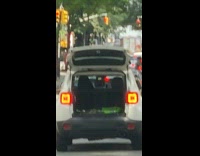 White car with open trunk street stoplight