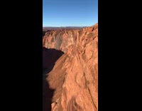 Grey sweater black pants edge red cliff 