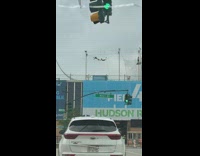 2 guys grab each other and swing from lines 