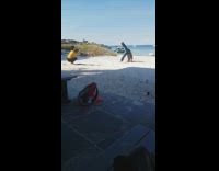 Man attempts to do headstand at beach