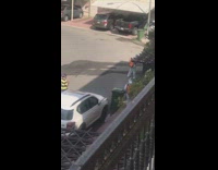 Two white hazmat suits spray disinfectant outside 