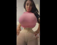 Woman poses with small waist and large breasts