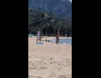 Man hands raised poses for beach photo