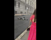 Multiple people lay on wet pavement floor