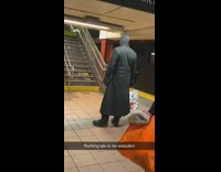Tall man black hoodie trench coat wait train