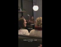 Girls use selfie stick at restaurant